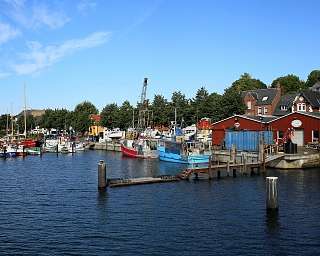 Blick auf einen Hafen mit verschiedenen Booten und bunten Gebäuden.