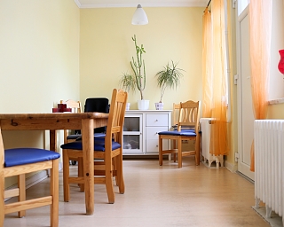 Ein Esszimmer mit Holzstühlen, Tisch und Pflanzen.