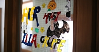 Fenster mit bunten Halloween-Motiven und Schriftzug.