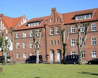 Ansicht von historischen Ziegelgebäuden und Skulptur im Freien.