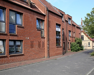 Ansicht von roten Ziegelhäusern entlang einer ruhigen Straße.